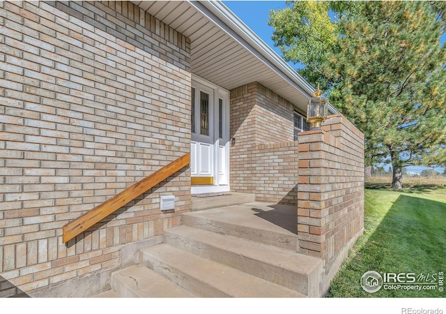 entrance to property featuring brick siding