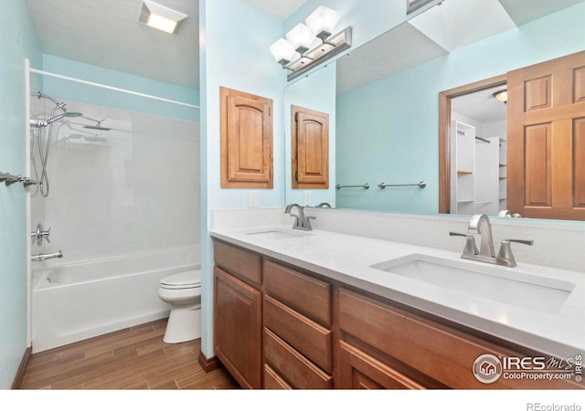 full bathroom featuring wood finished floors, shower / bath combination, a sink, and toilet