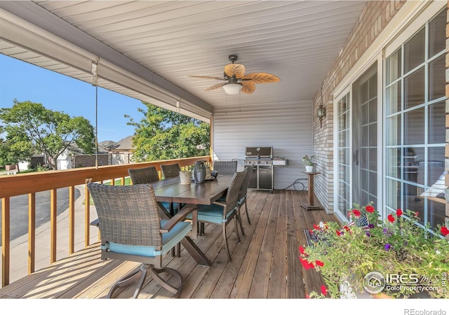 wooden terrace featuring outdoor dining space, a grill, and a ceiling fan