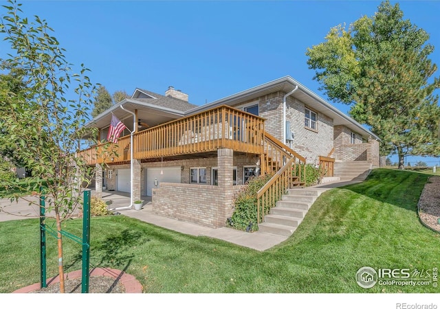 back of house featuring a garage, a yard, stairs, and brick siding