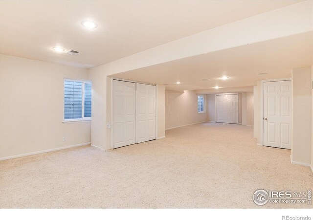 finished below grade area with recessed lighting, light colored carpet, visible vents, and baseboards