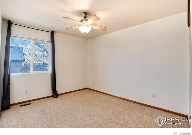 unfurnished room featuring light carpet, baseboards, visible vents, and a ceiling fan