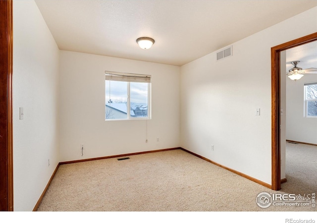 unfurnished room with light carpet, visible vents, and baseboards