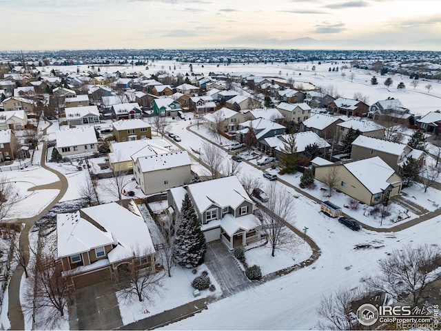 snowy aerial view with a residential view