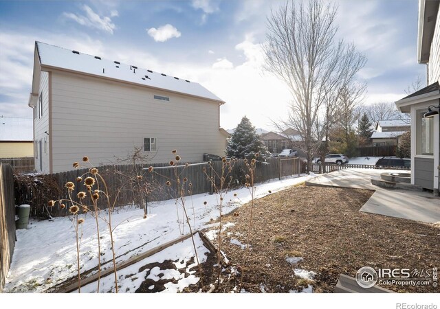 view of snowy exterior with fence