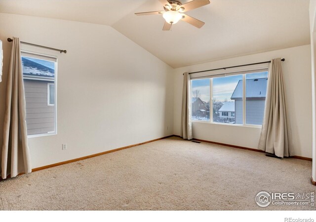 empty room featuring baseboards, vaulted ceiling, a ceiling fan, and light colored carpet