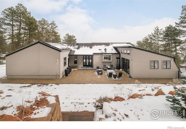 snow covered property with a patio