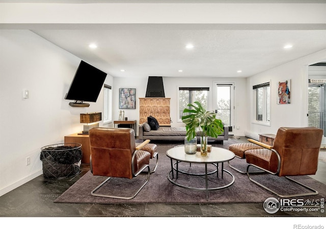 living area featuring baseboards, recessed lighting, and a healthy amount of sunlight