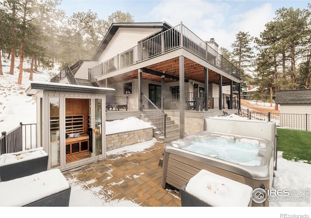 exterior space featuring a hot tub, a patio area, fence, a balcony, and stairs