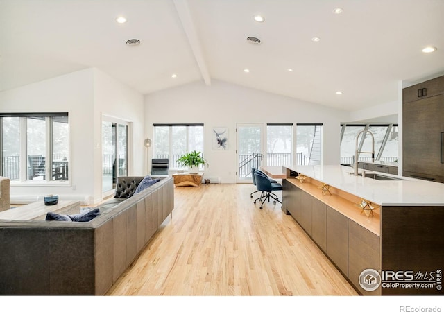 living area with high vaulted ceiling, light wood finished floors, visible vents, and beamed ceiling