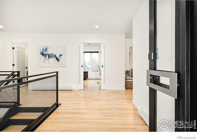 hallway with light wood-type flooring, baseboards, and recessed lighting