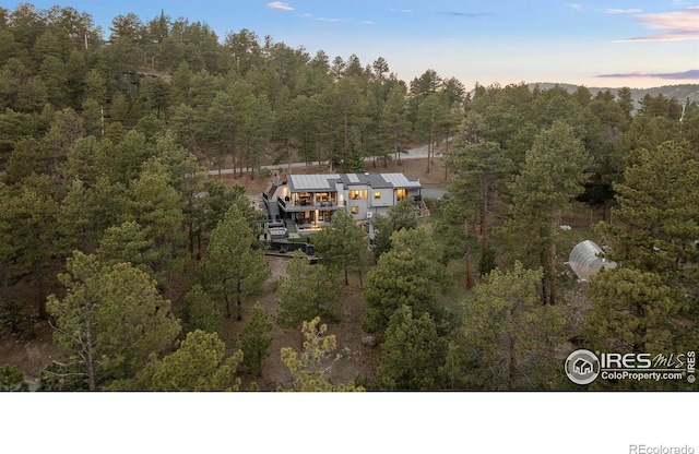 birds eye view of property featuring a wooded view