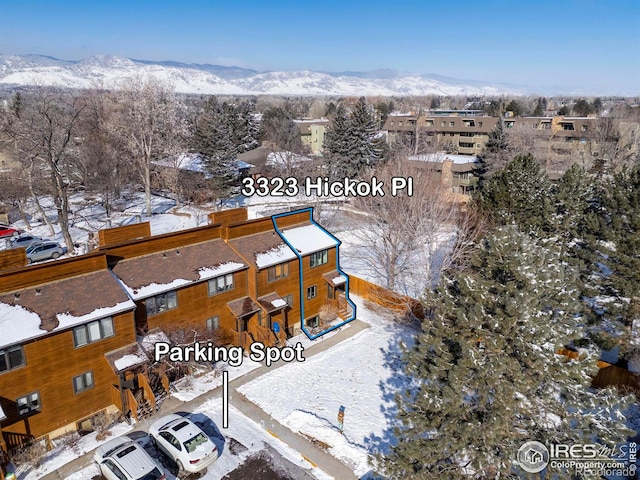 snowy aerial view featuring a residential view and a mountain view