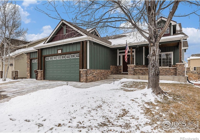 view of front of home featuring board and batten siding, stone siding, and an attached garage