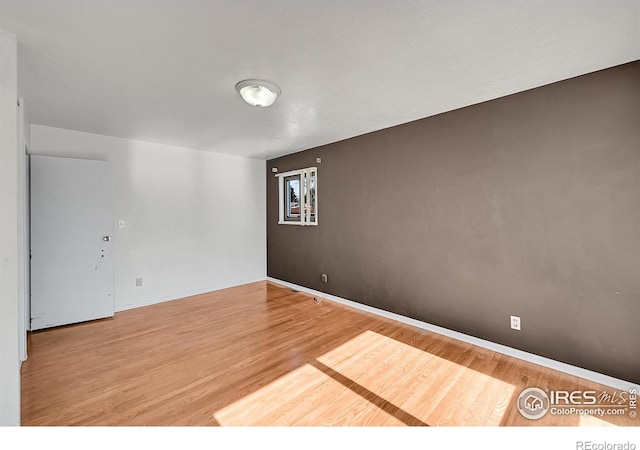 empty room featuring baseboards and wood finished floors