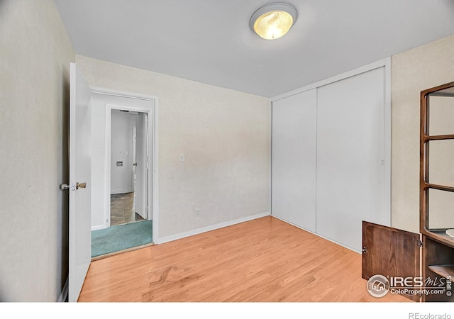 unfurnished bedroom featuring a closet and light wood-type flooring