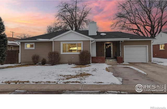 single story home featuring a garage, concrete driveway, brick siding, and a chimney