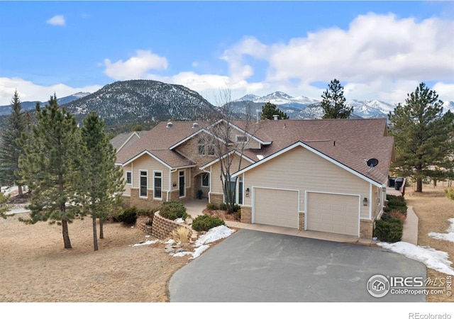 craftsman inspired home with a garage, driveway, brick siding, and a mountain view