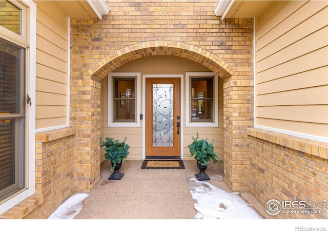 entrance to property featuring brick siding