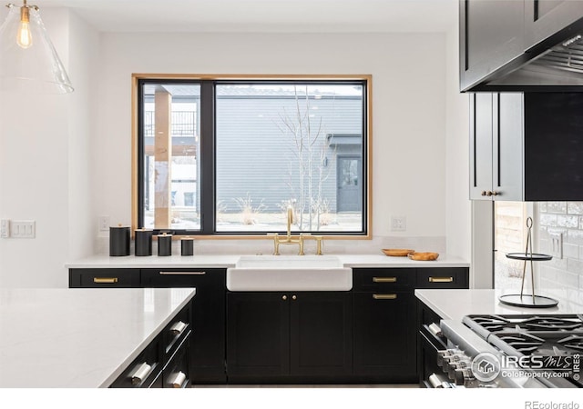 kitchen featuring a sink, dark cabinetry, and light countertops