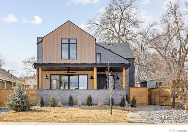 view of front of property featuring a gate, fence, and brick siding