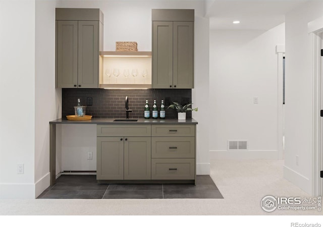 kitchen featuring visible vents, backsplash, gray cabinetry, a sink, and open shelves