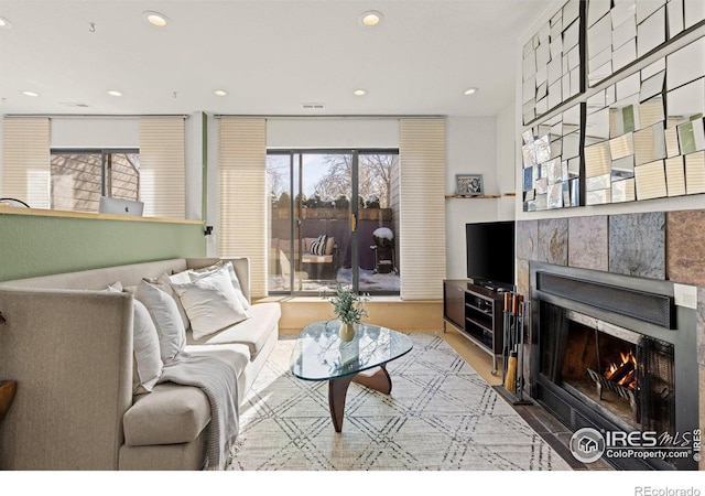 living area with a tile fireplace and recessed lighting