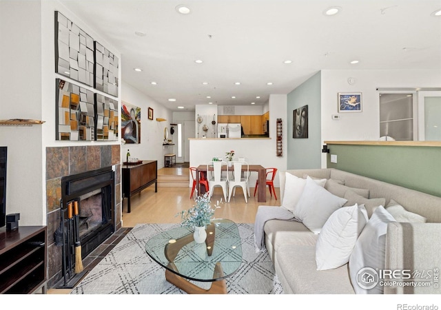 living area with light wood-type flooring, a fireplace, and recessed lighting