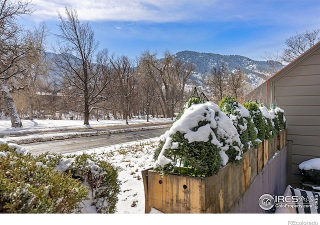 snowy yard featuring fence and a mountain view