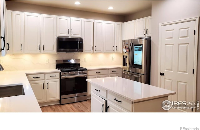 kitchen featuring light countertops, appliances with stainless steel finishes, and white cabinetry