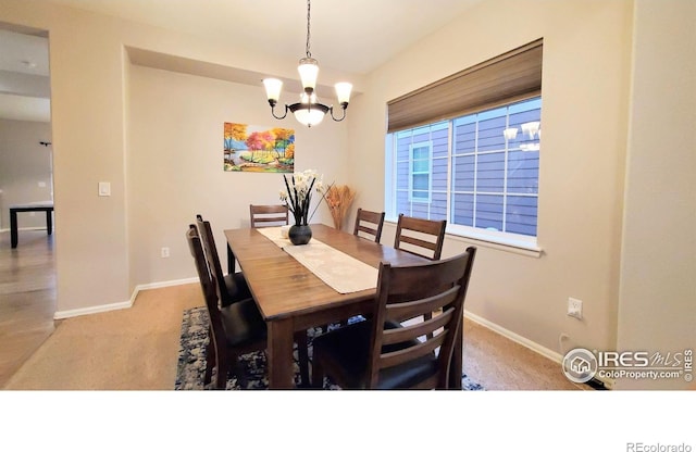 dining room with light carpet, baseboards, and an inviting chandelier