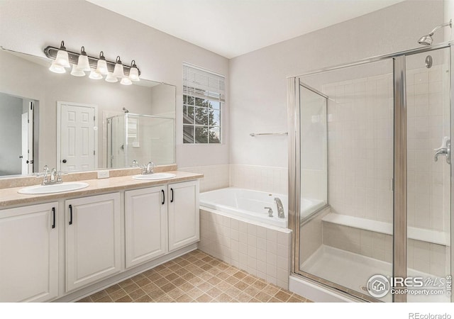 bathroom with double vanity, a sink, a shower stall, and a bath