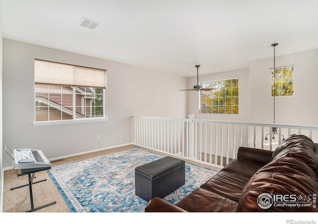 living area with carpet, visible vents, and baseboards