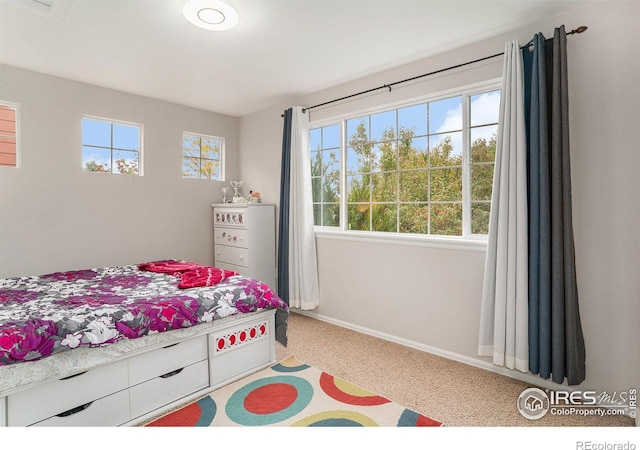 bedroom with baseboards and light colored carpet