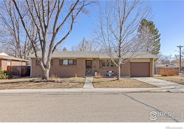 ranch-style house with concrete driveway, brick siding, an attached garage, and fence