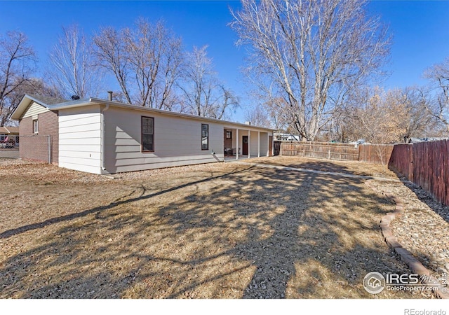 back of property with a patio, brick siding, and a fenced backyard