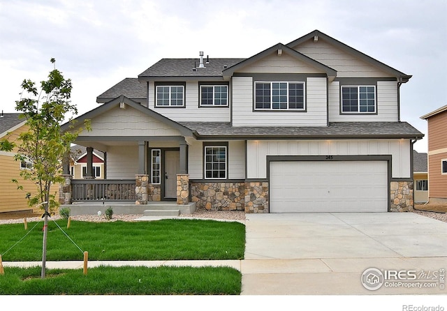 craftsman inspired home featuring a porch, an attached garage, concrete driveway, board and batten siding, and a front yard