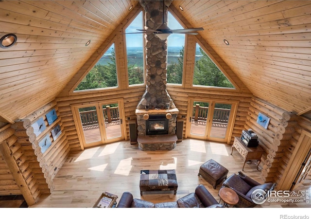 unfurnished living room with high vaulted ceiling, wooden ceiling, and a wood stove