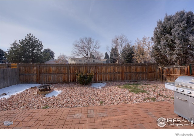 deck featuring a fenced backyard, a fire pit, and a patio