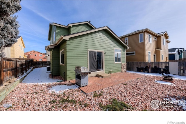 rear view of property featuring a fenced backyard and a fire pit