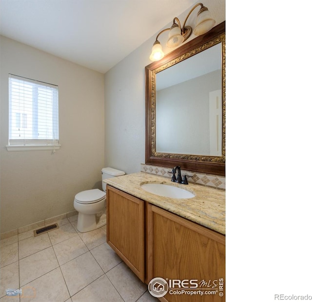 bathroom with toilet, vanity, visible vents, and tile patterned floors