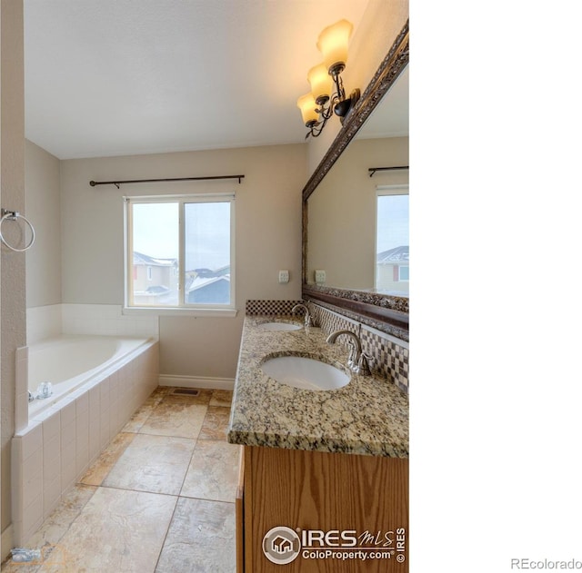 bathroom with double vanity, a garden tub, and a sink