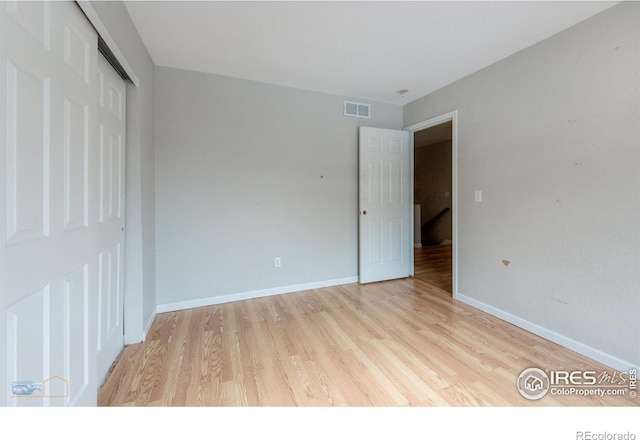 unfurnished bedroom featuring light wood finished floors, a closet, visible vents, and baseboards