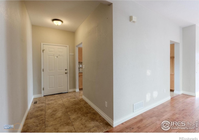 hallway featuring visible vents and baseboards