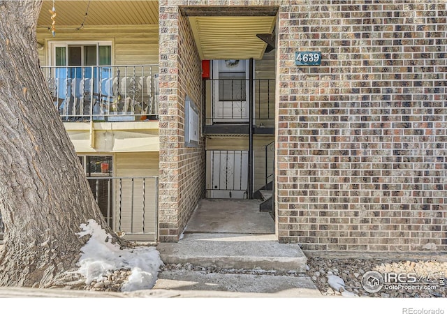 entrance to property featuring brick siding