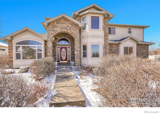 traditional-style home with stone siding and stucco siding