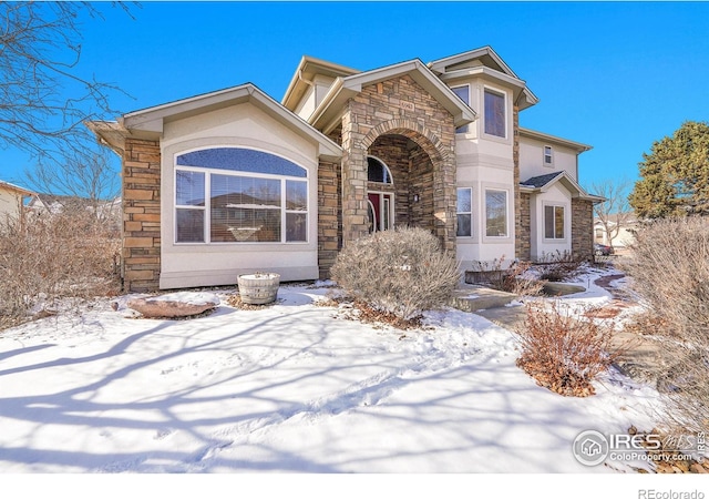 view of front facade with stone siding and stucco siding