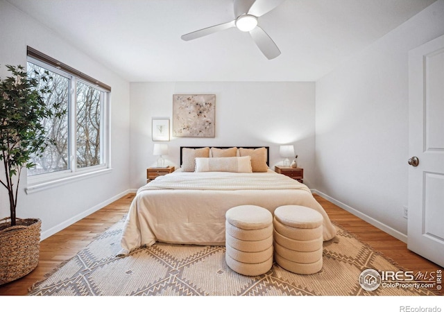 bedroom with ceiling fan, baseboards, and wood finished floors