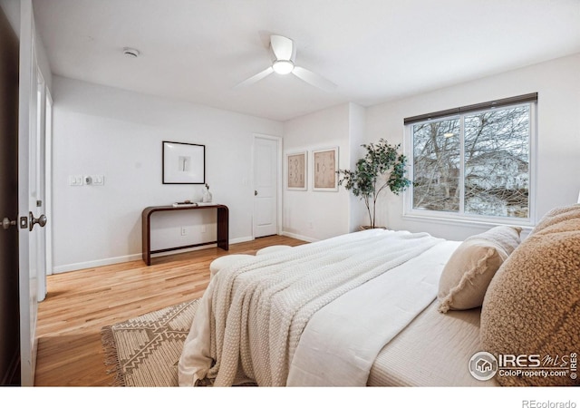 bedroom featuring ceiling fan, light wood finished floors, and baseboards