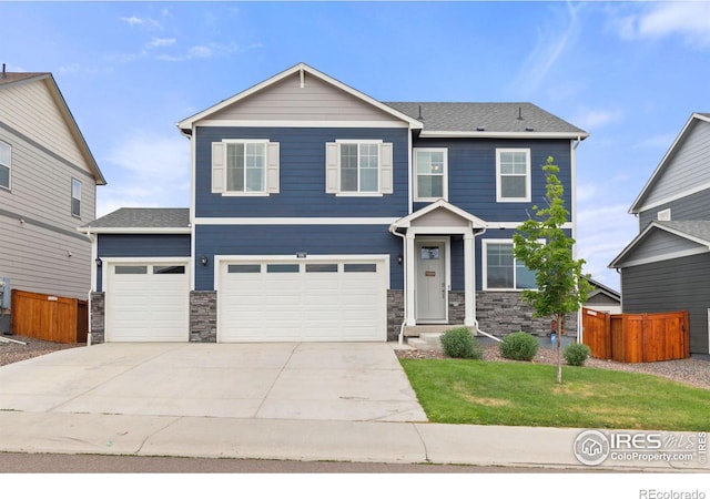 view of front of house with stone siding, fence, a front lawn, and concrete driveway